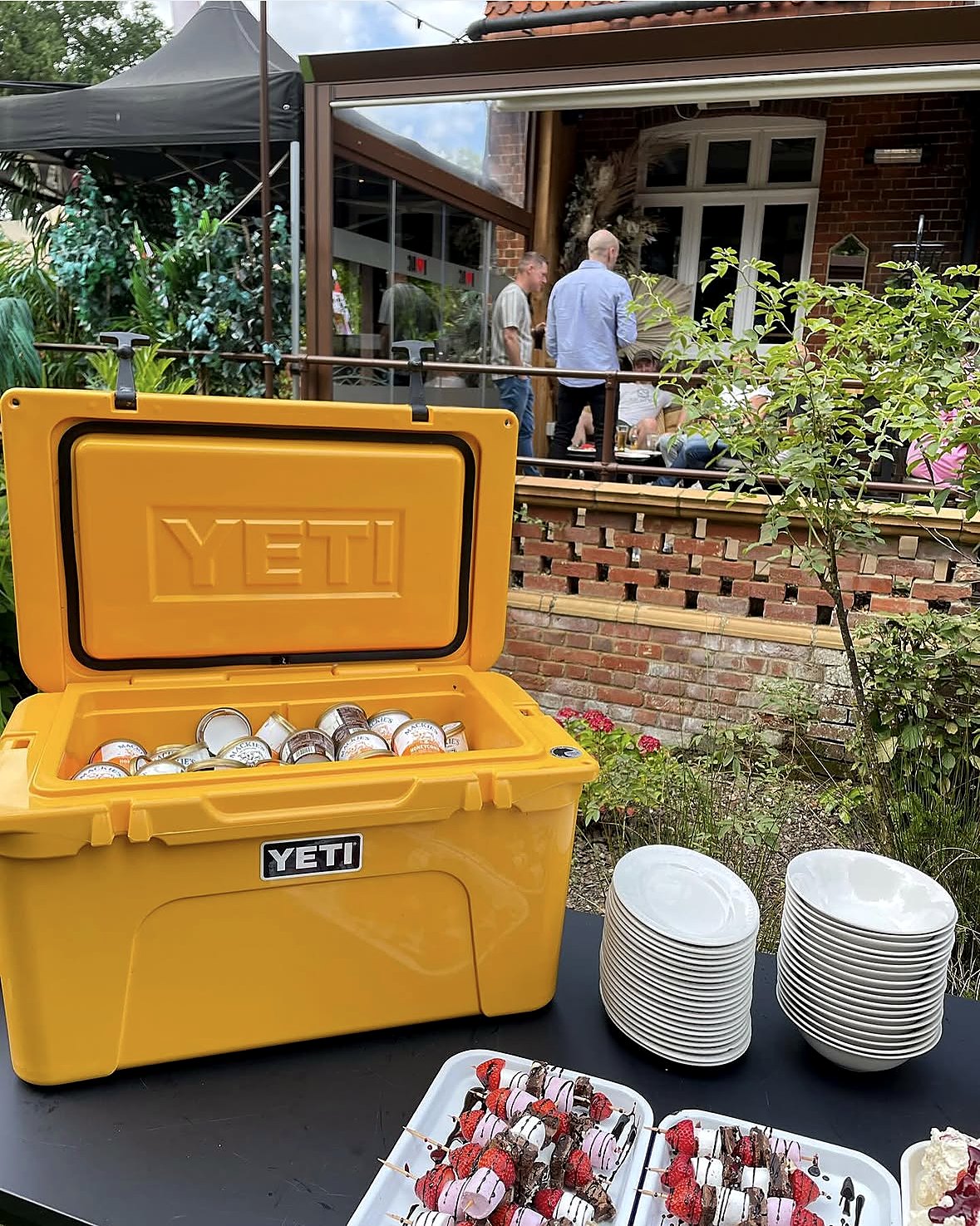 Dessert station with ice cream cooler and strawberry skewers at a corporate summer BBQ