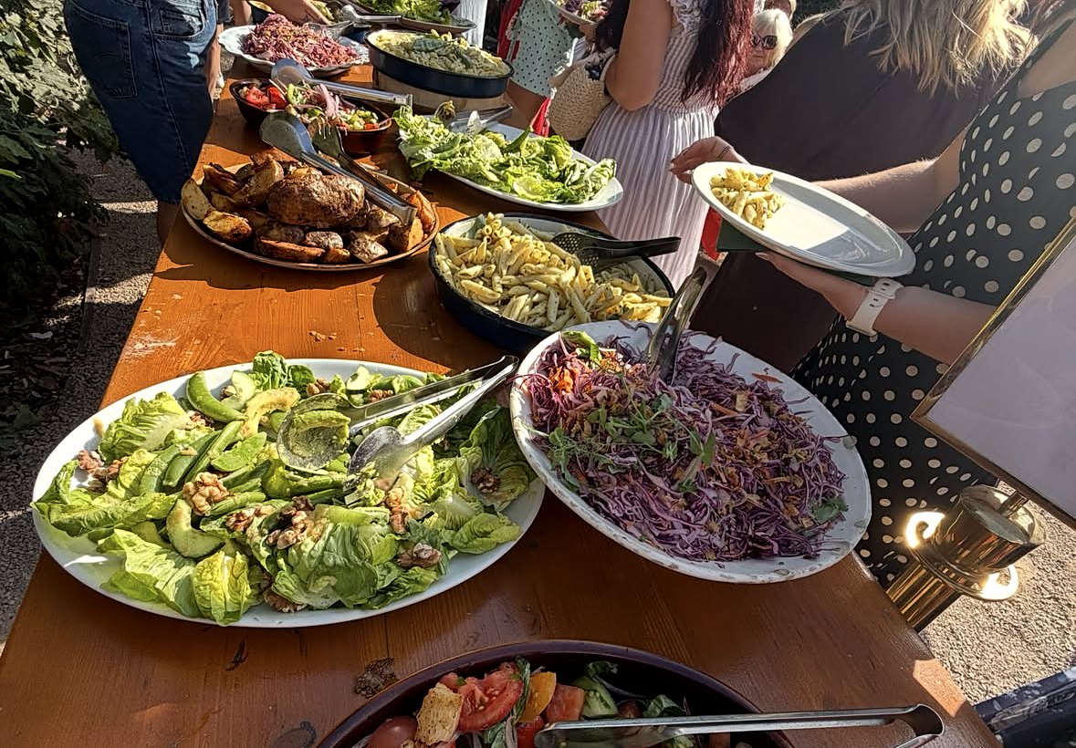 Wedding guests serving themselves from a summer buffet